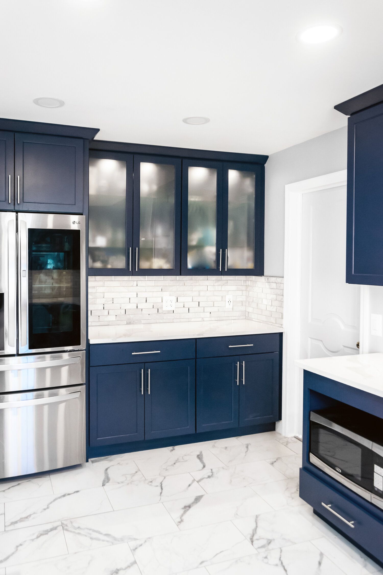 A kitchen with blue cabinets and stainless steel appliances