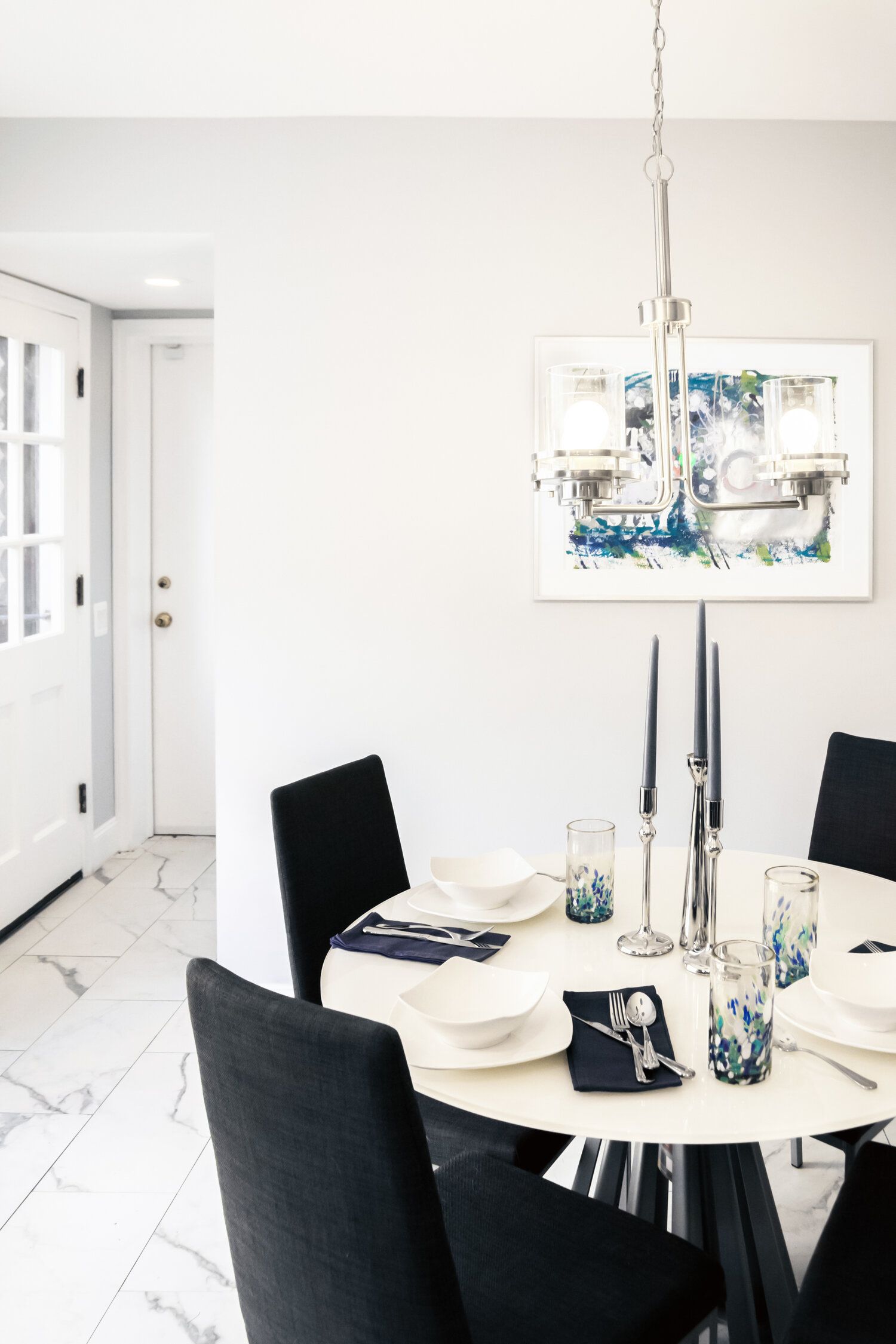 A dining room with a round table and black chairs