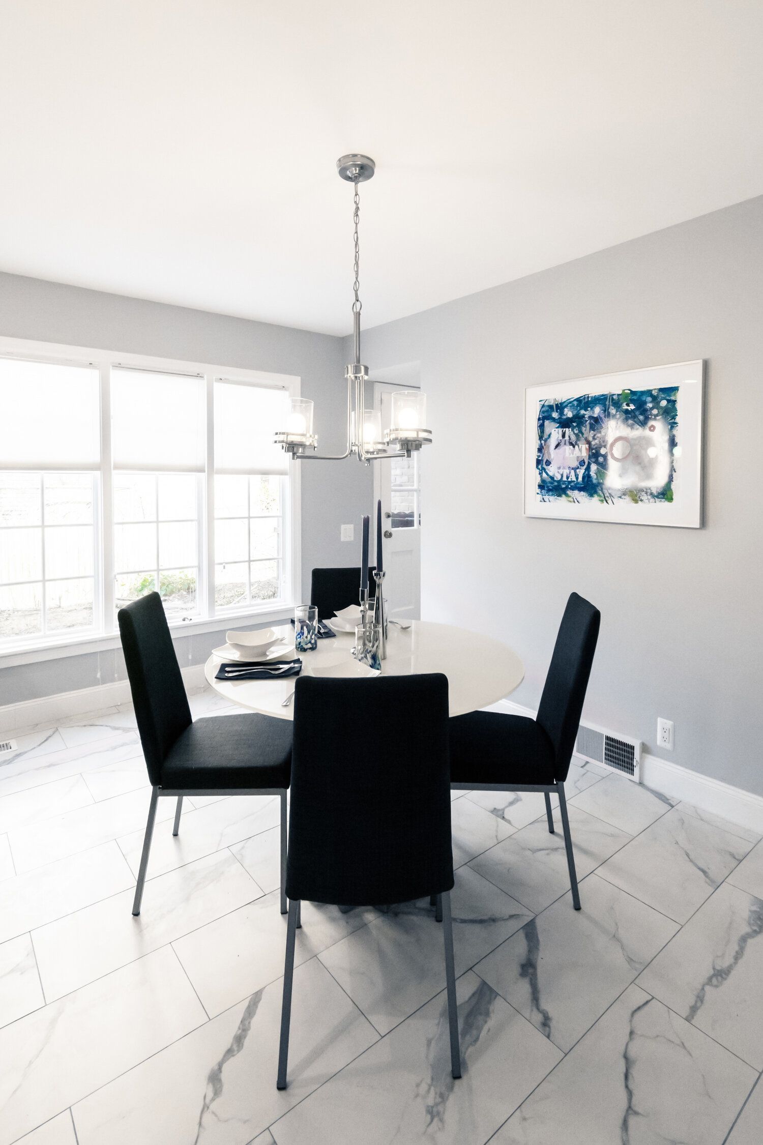 A dining room with a table and chairs and a chandelier.