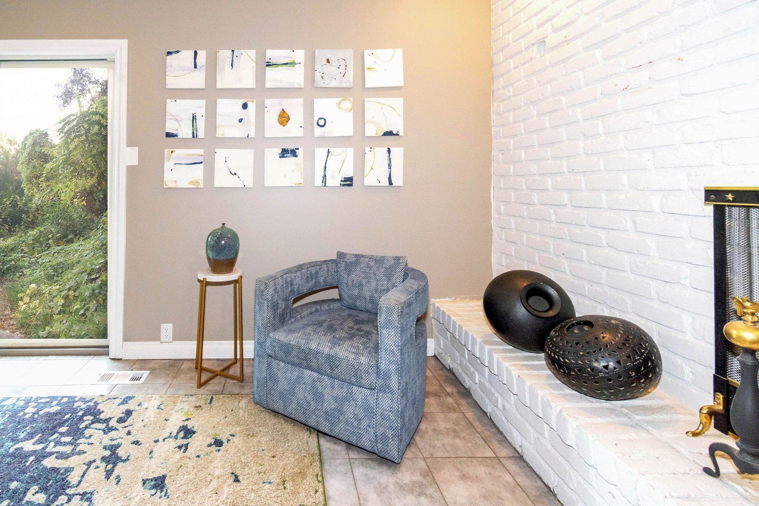 A living room with a blue chair and a fireplace.