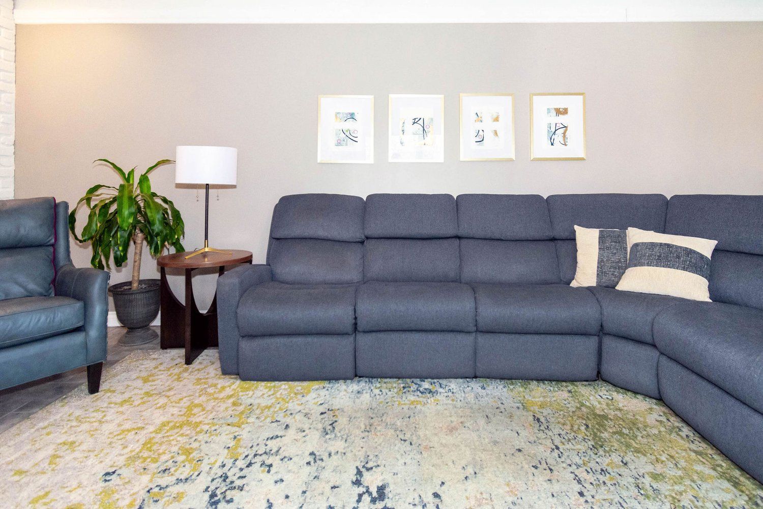 A living room with a large sectional couch and a chair.