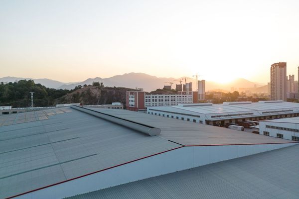 An aerial view of a roof of a building with mountains in the background at sunset.