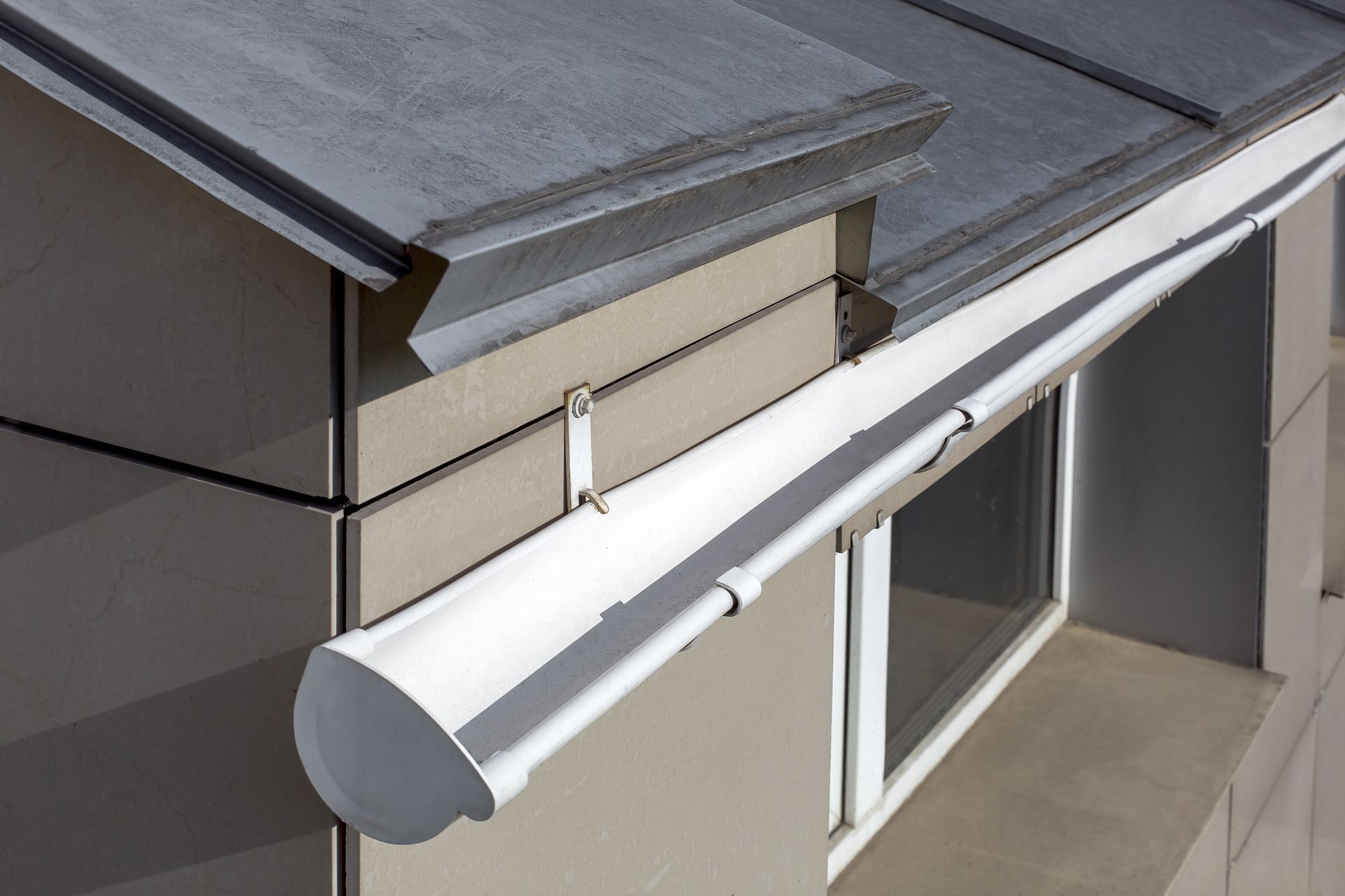 White awning over a window on a beige house exterior