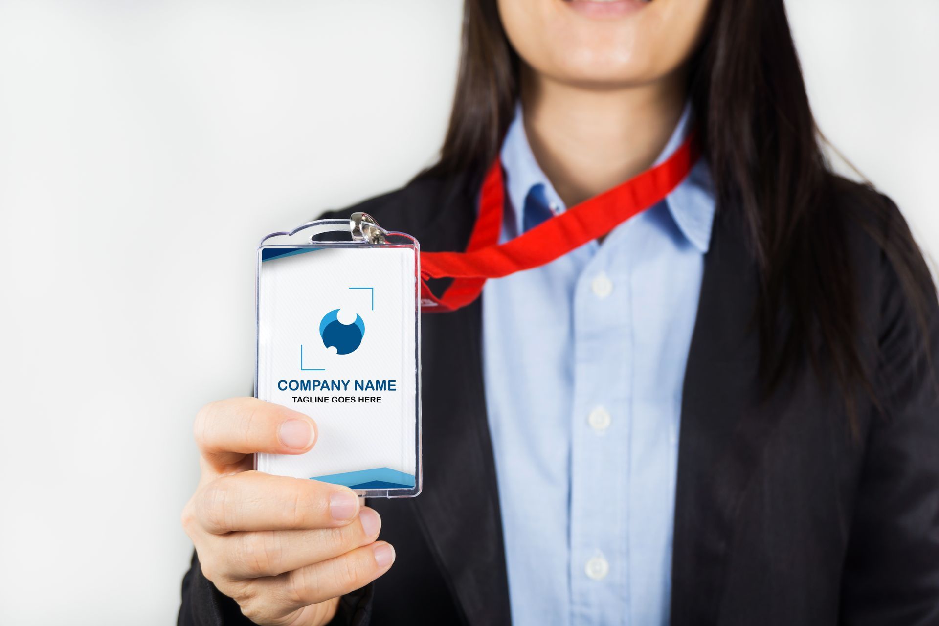 Mujer con traje sosteniendo una credencial de identificación en un cordón rojo.