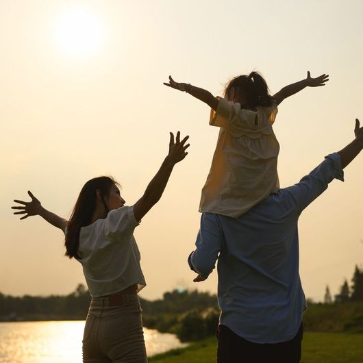 A man is carrying a little girl on his shoulders