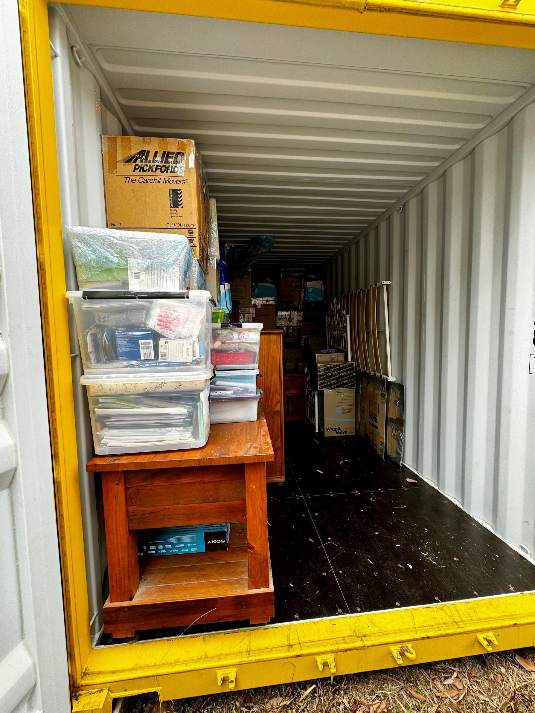 Two Movers in Blue Overalls Loading Cardboard Boxes Into a Truck, Outdoors Near a House — Uplift Removals in Marsden, QLD