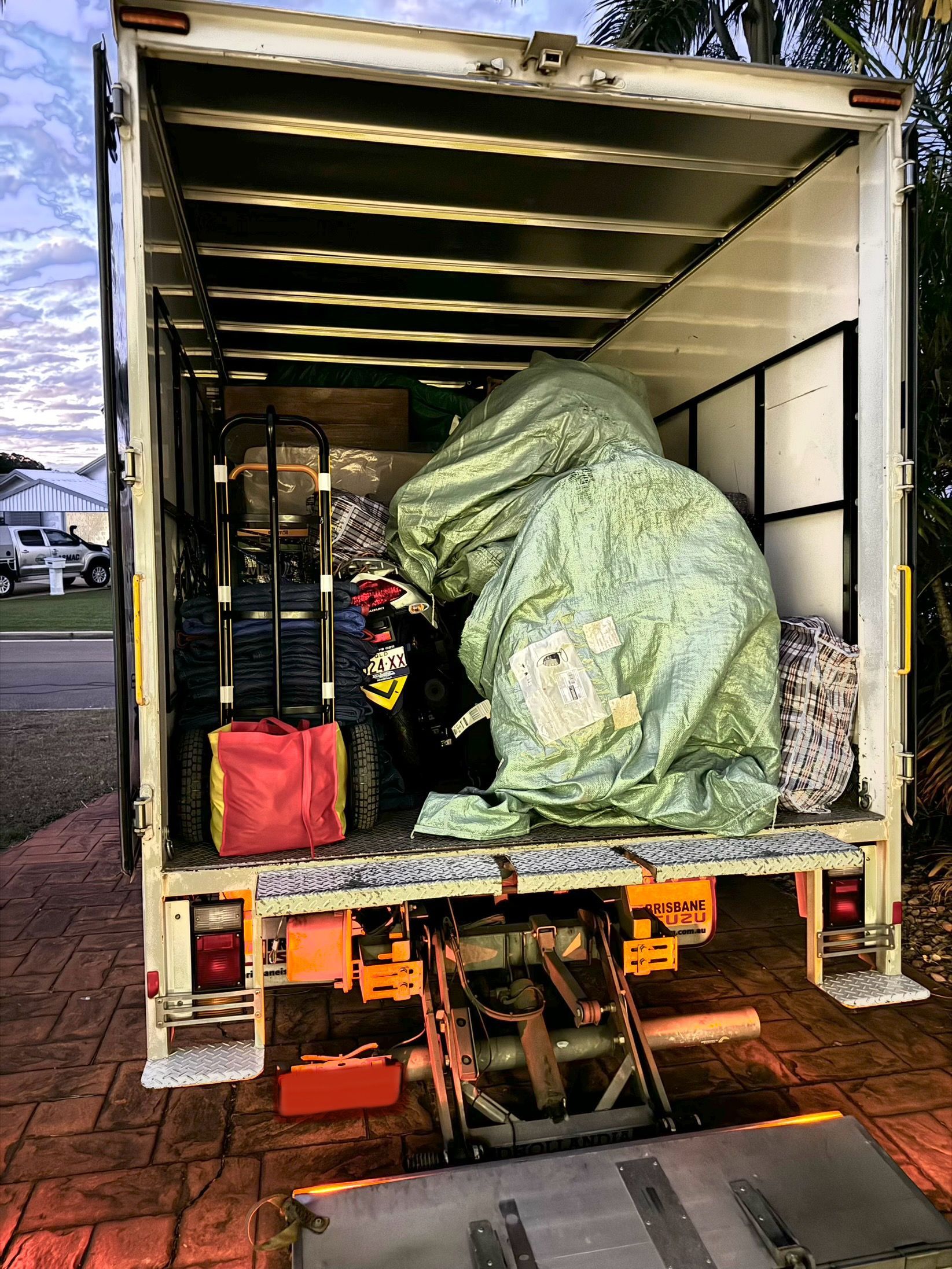 Movers in Blue Uniforms Loading Cardboard Boxes Into a Van — Uplift Removals in Ipswich, QLD