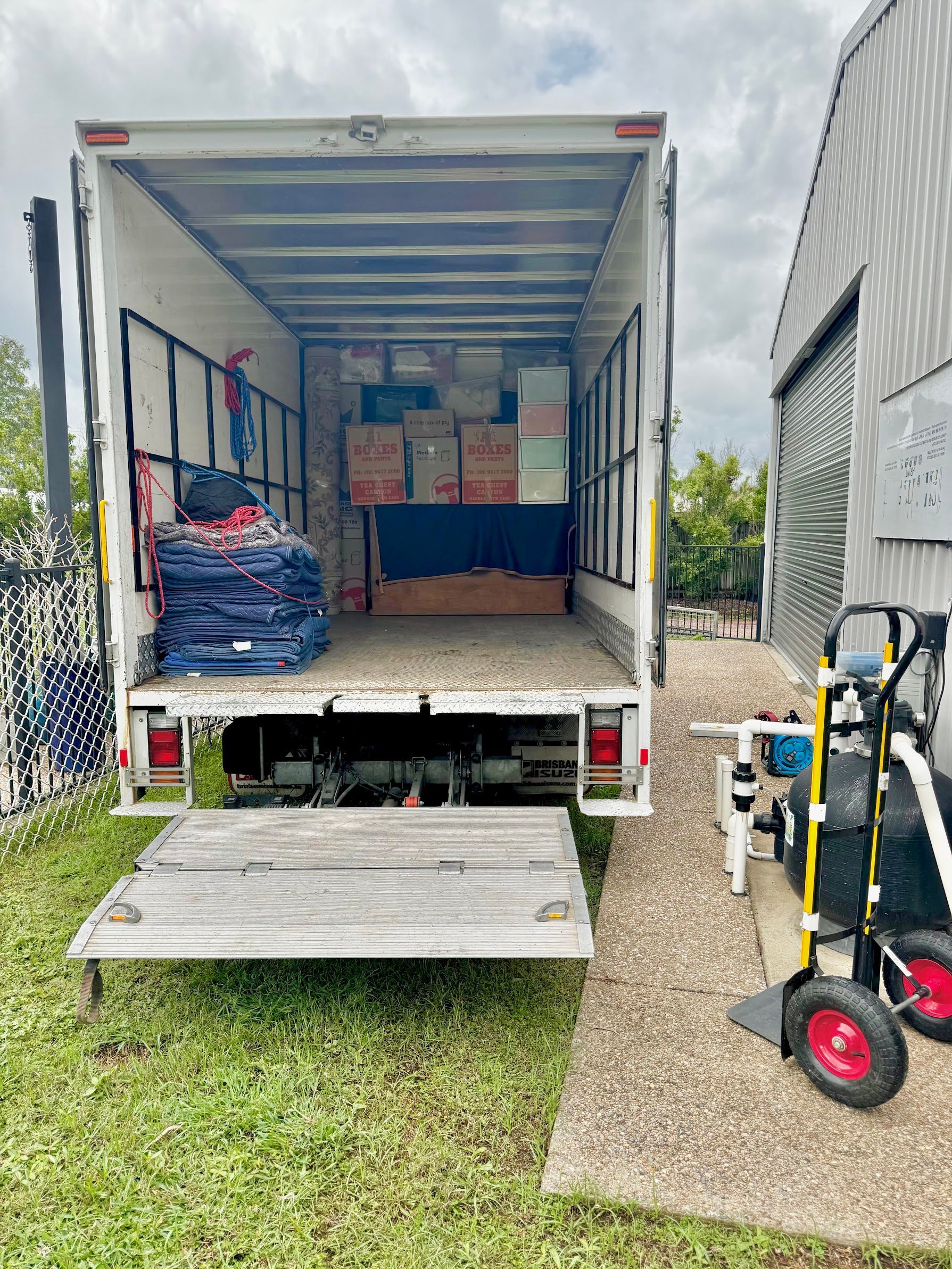 A Pallet Truck Is Carrying A Large Box In A Warehouse — Uplift Removals in Burdell, QLD