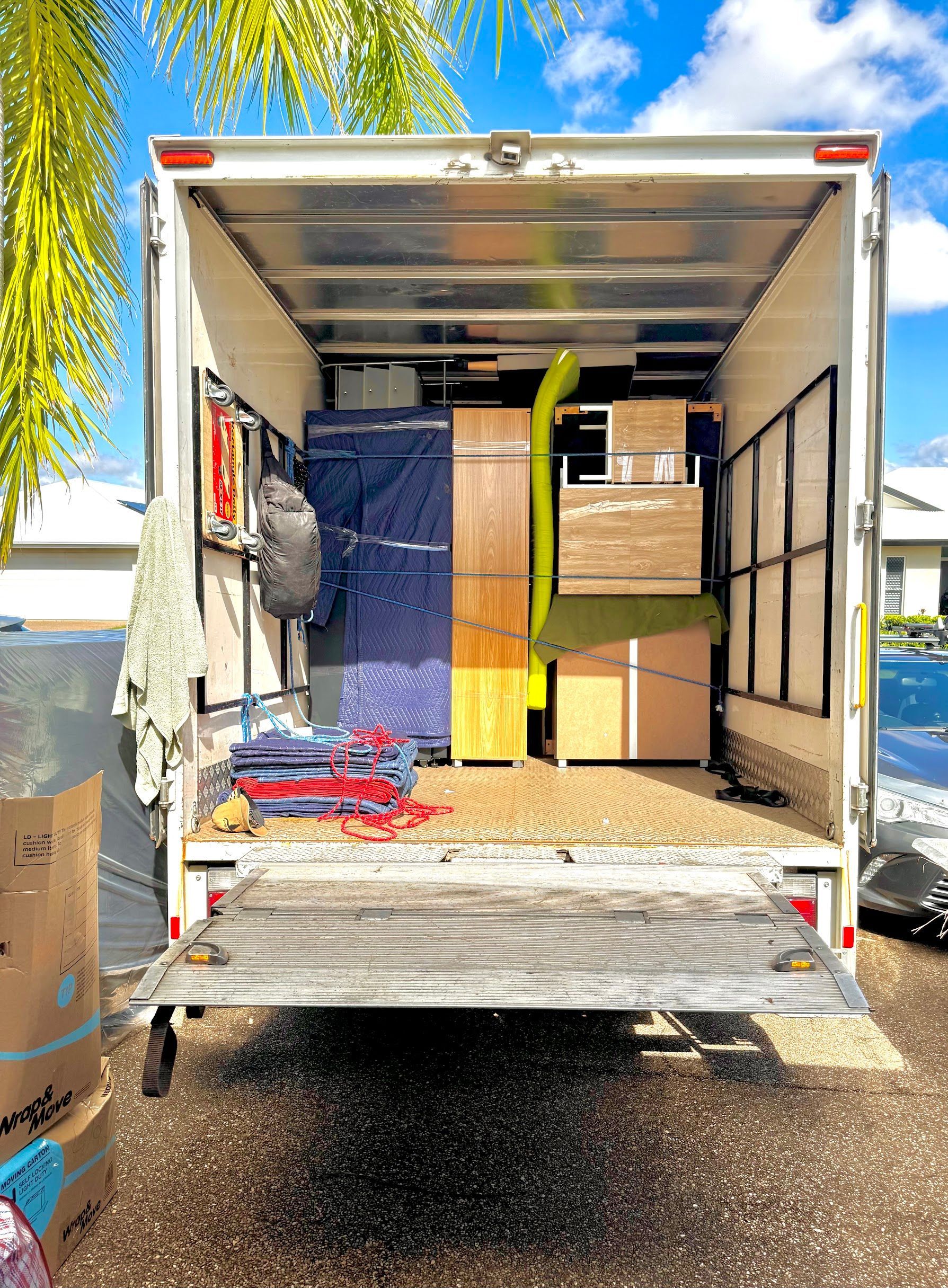 White Delivery Truck With Open Back Containing Stacked Cardboard Boxes — Uplift Removals in Brisbane, QLD