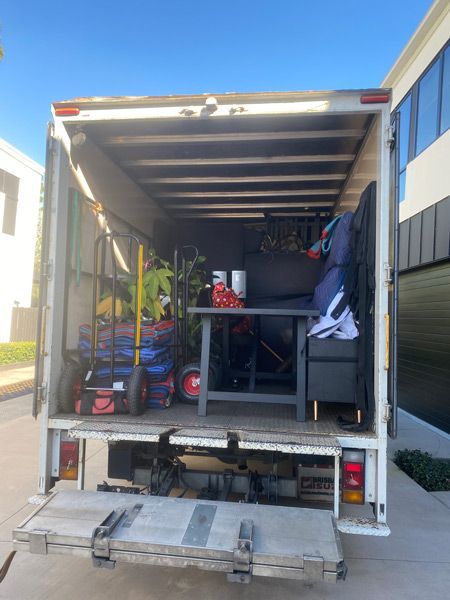 The Back Of A Moving Truck Is Open And Filled With Furniture — Uplift Removals in Burdell, QLD