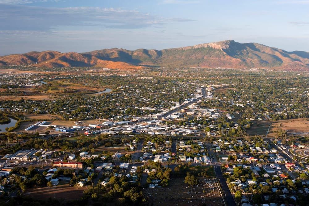 Wide Aerial View of A Suburban Town Spread Across a Valley with Mountains — Uplift Removals in Burdell, QLD