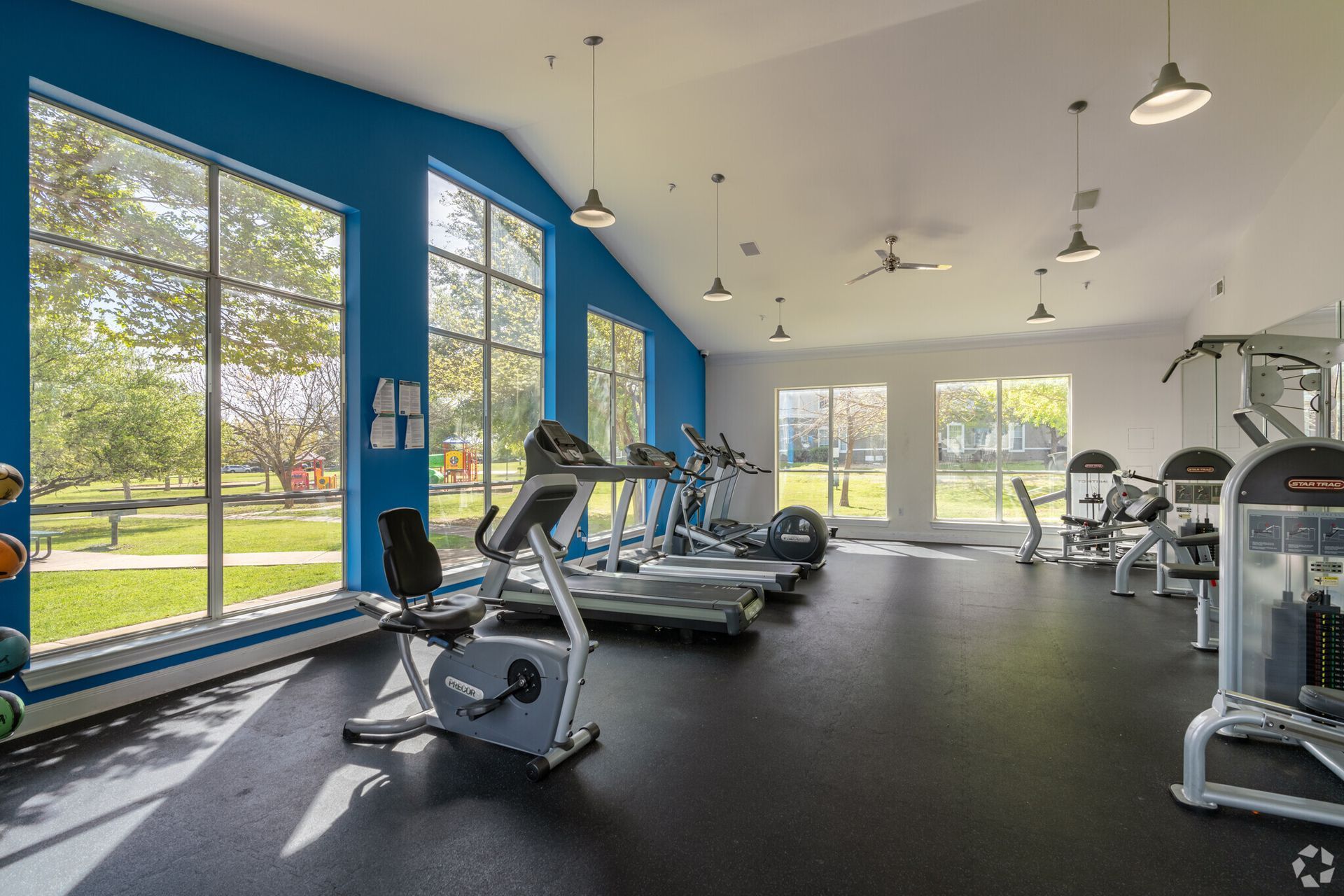 A large gym with a lot of treadmills and exercise bikes.