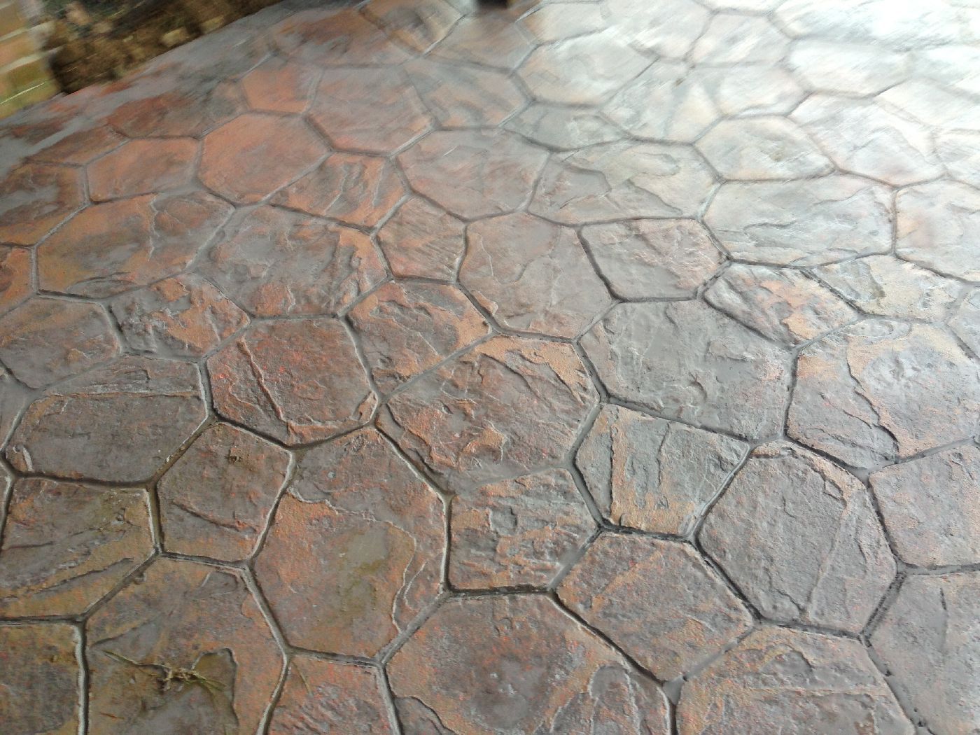 Textured stamped concrete surface in gray and rust tones