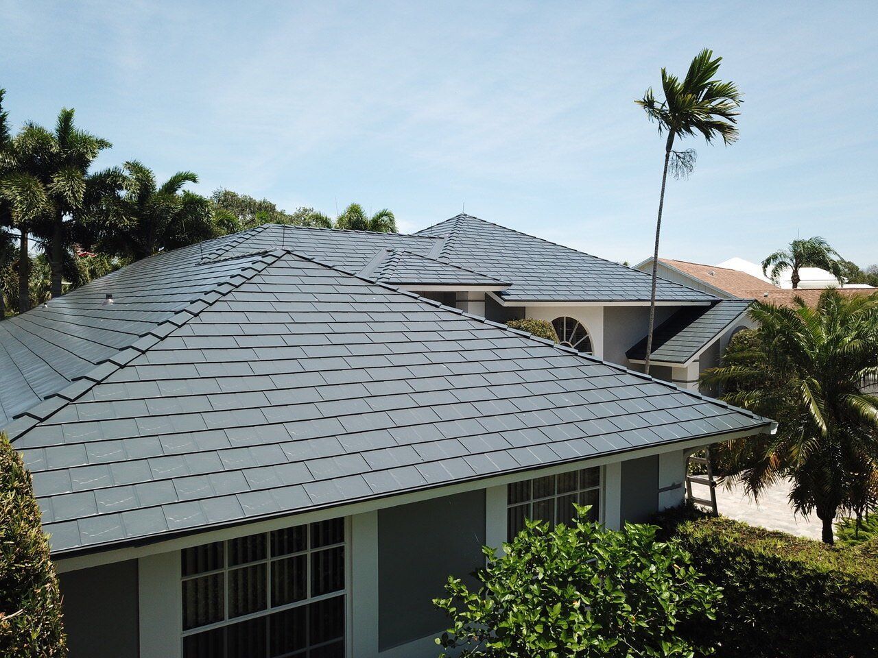 Tequesta FL Jupiter Inlet Deep Charcoal Interlock Slate Metal Roofing System close-up of the roofing with palm tree in background