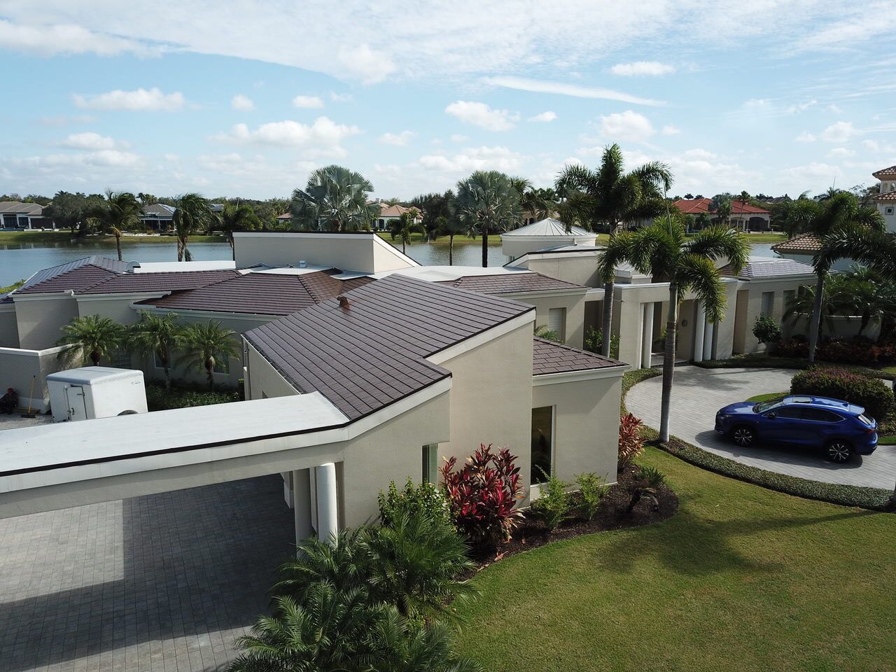 Naples FL Colonial Brown Interlock Cedar Shingle install on a beautiful rancher home with pool. Nice garden, home is on a waterway with palm trees
