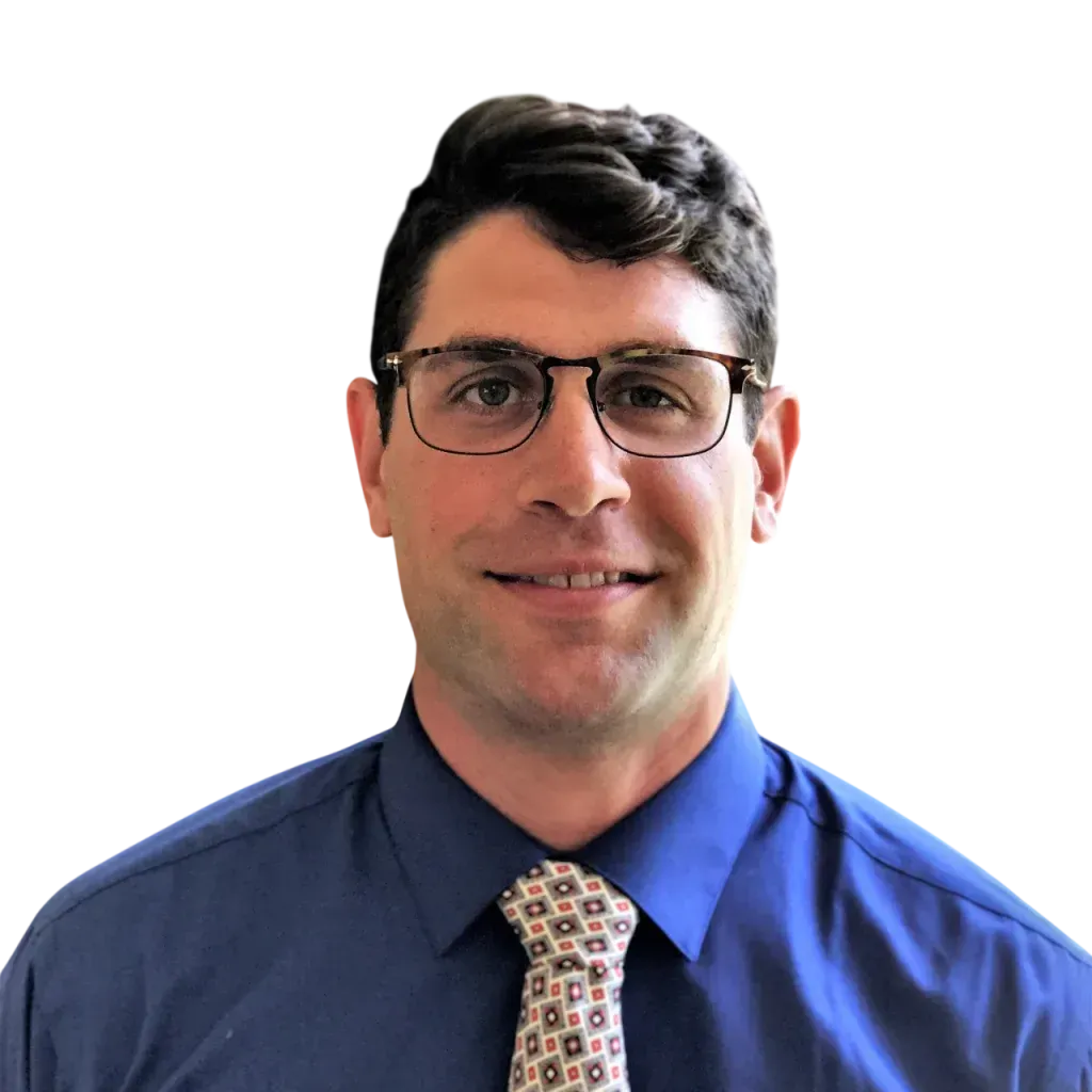 Portrait of a man in glasses wearing a blue shirt and patterned tie against a white background