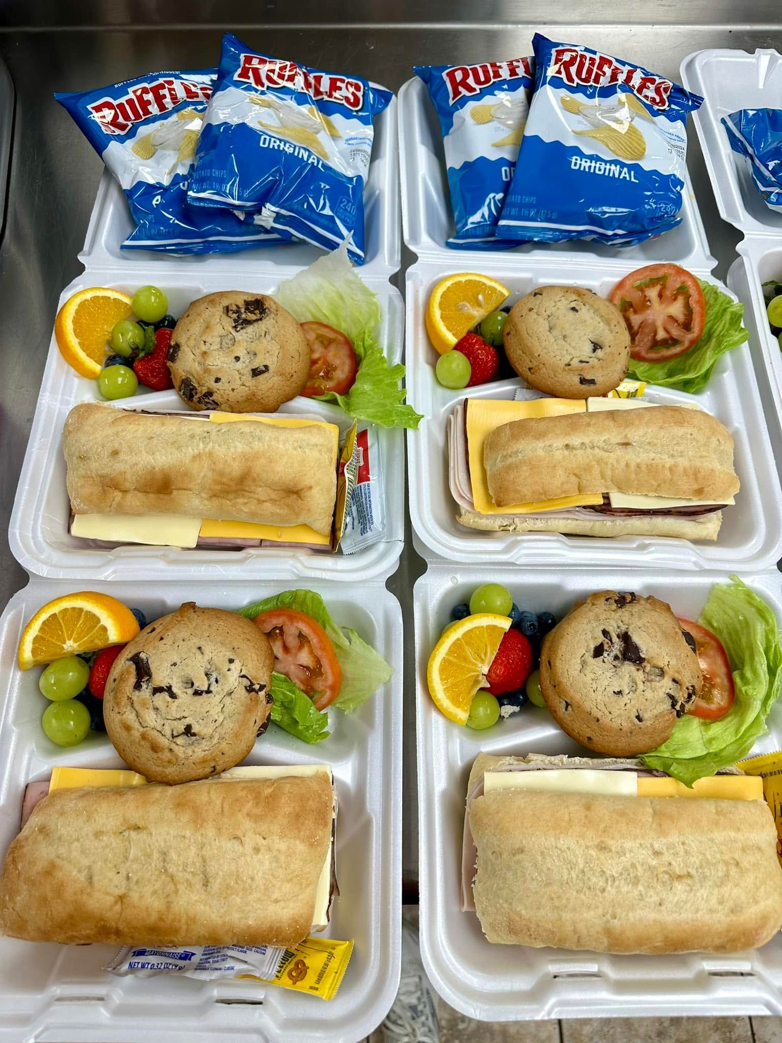 boxed sandwich lunch with chips and fruit