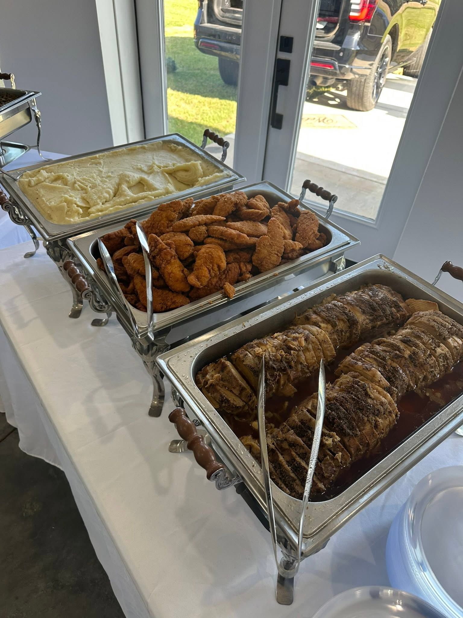 pork loin, mashed potatoes, and chicken strips in chafing dishes