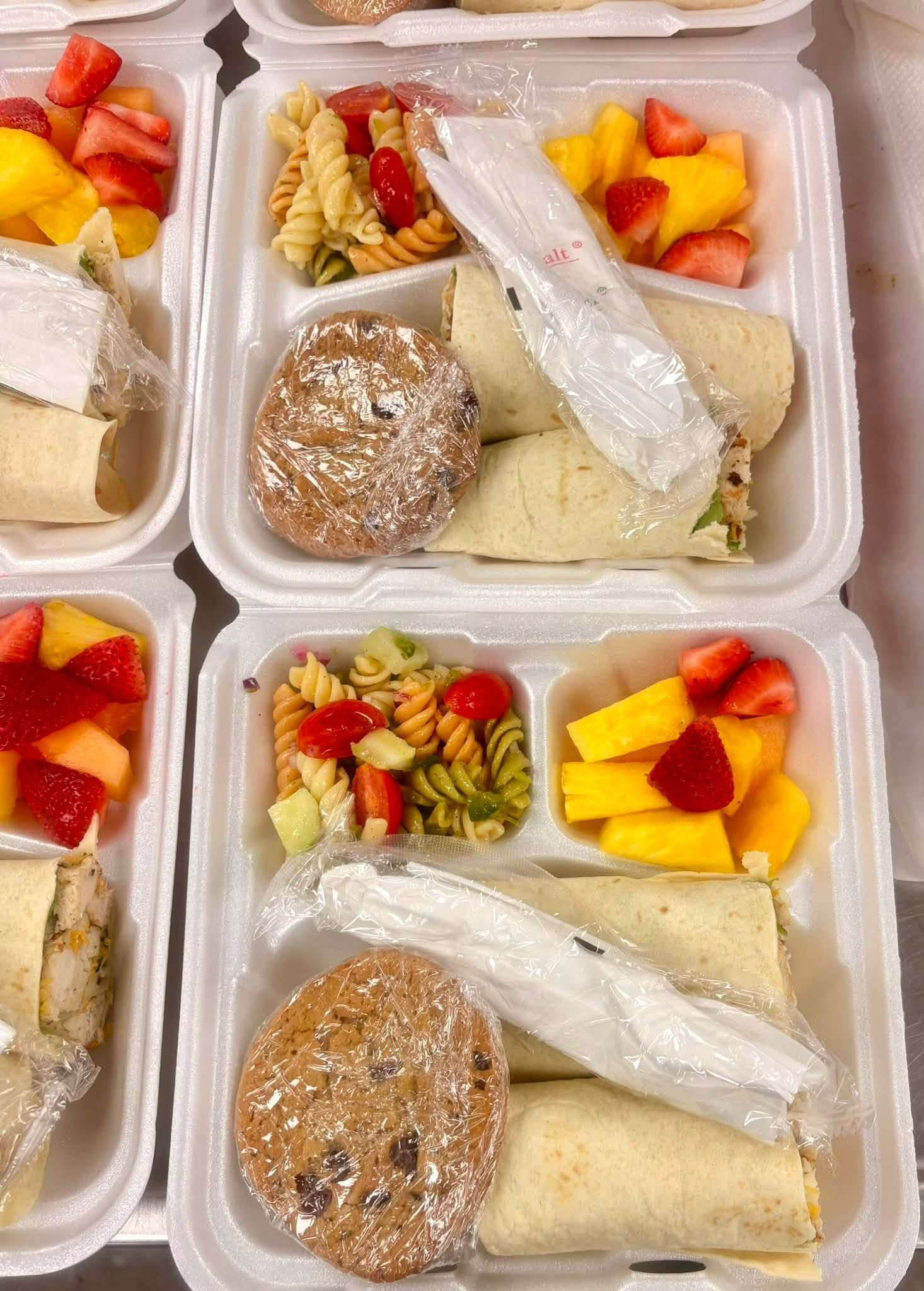 boxed meal with wrap, pasta salad, fruit, and cookie