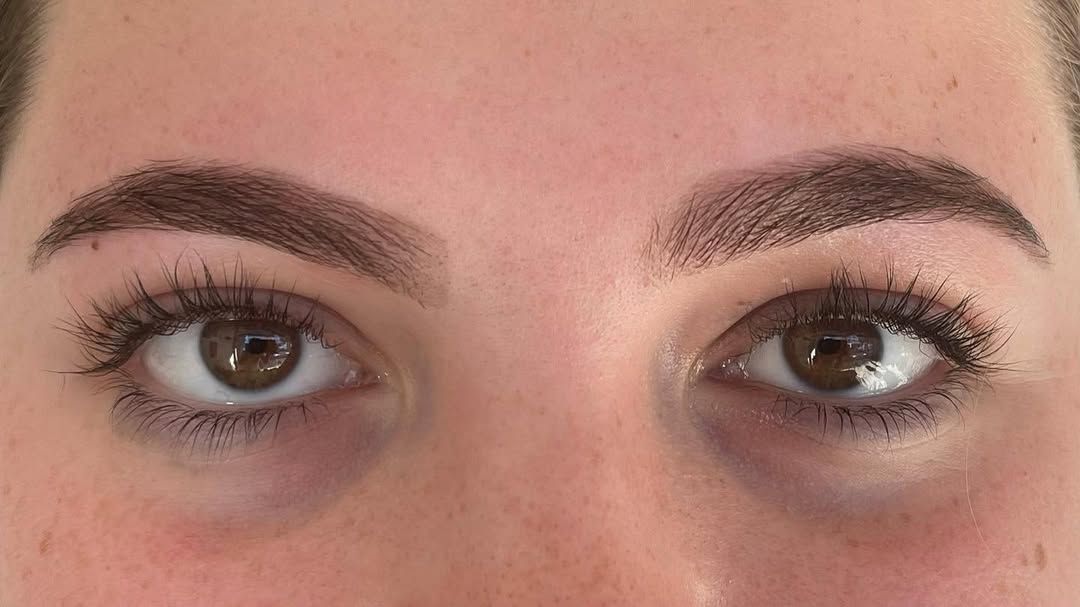 Close-up of a person's face with brown eyebrows, eyes, and visible eyelashes.