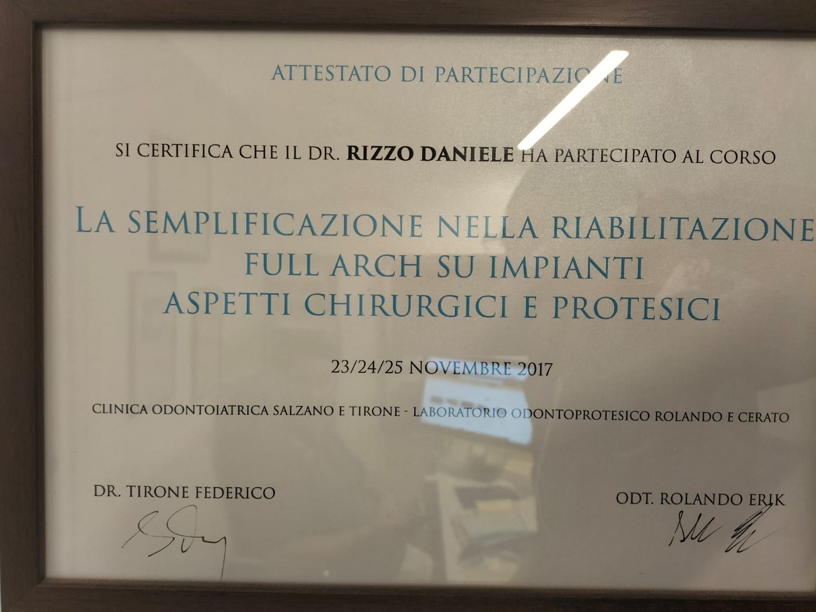 Attestato di partecipazione a un corso di riabilitazione implantare dell'intera arcata, in italiano, con firme e sfondo beige.