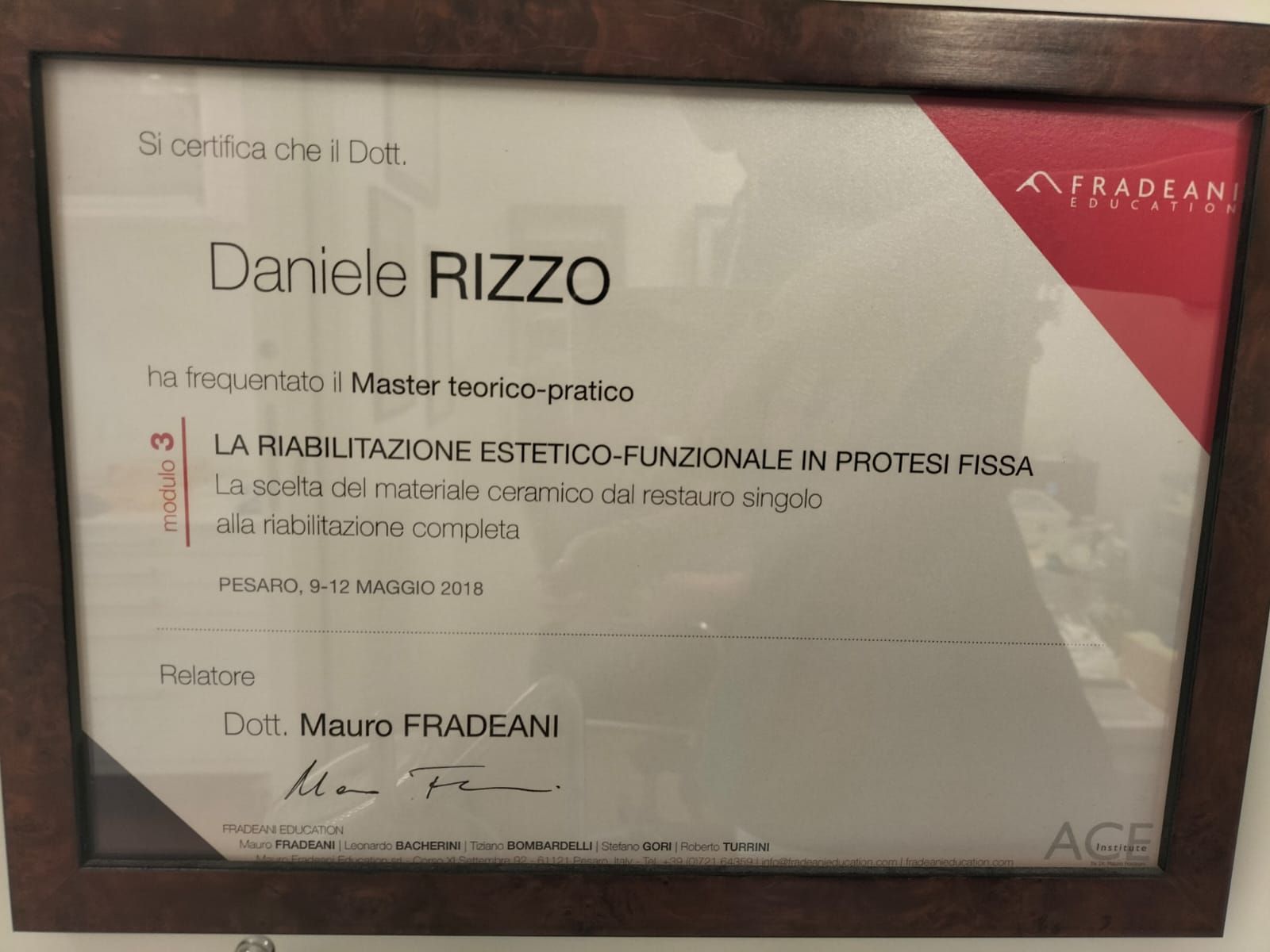 Certificato italiano incorniciato con sfondo beige e angoli rossi, recante il nome di Daniele Rizzo.