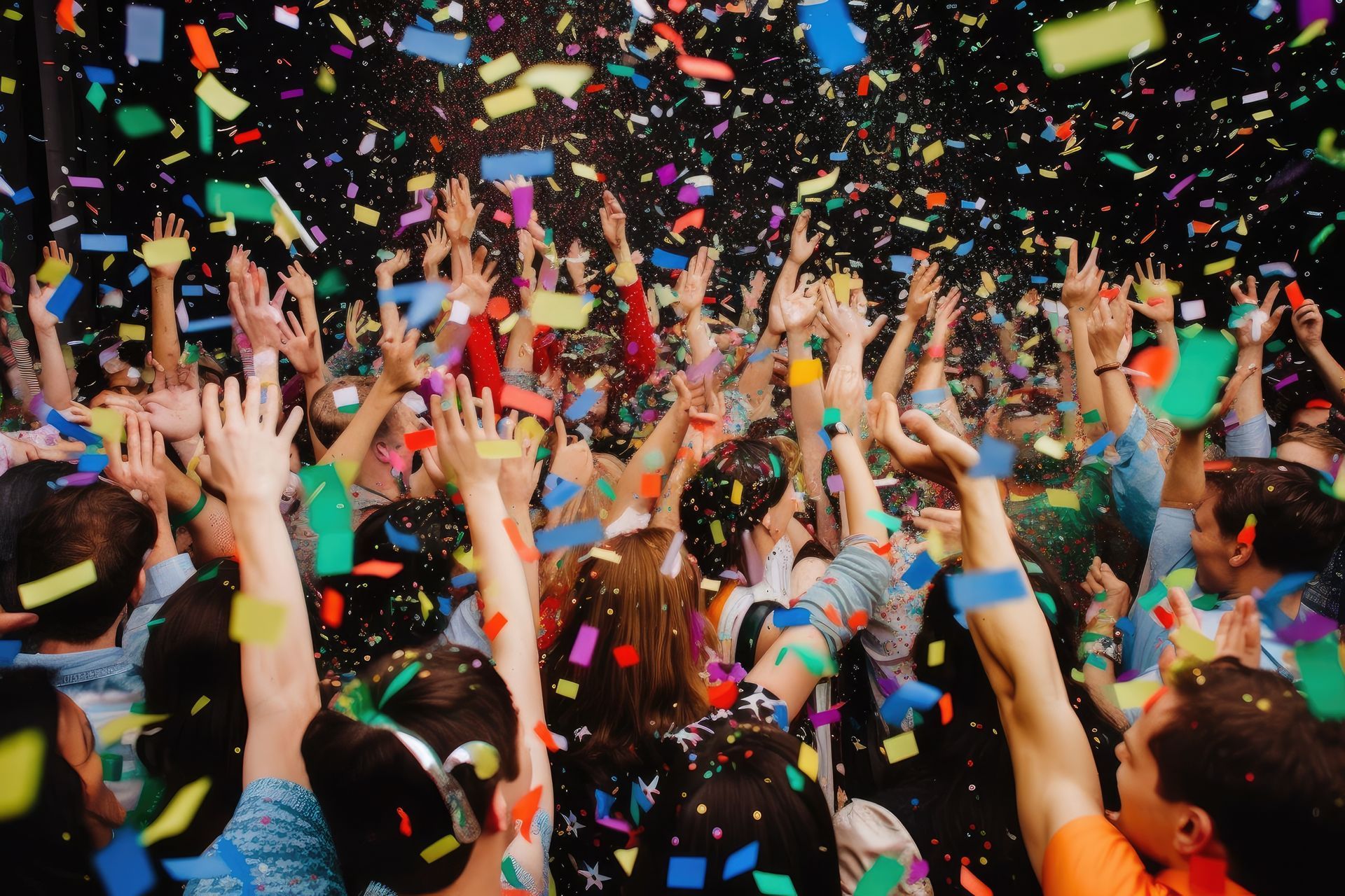 People with raised arms celebrating with confetti falling.