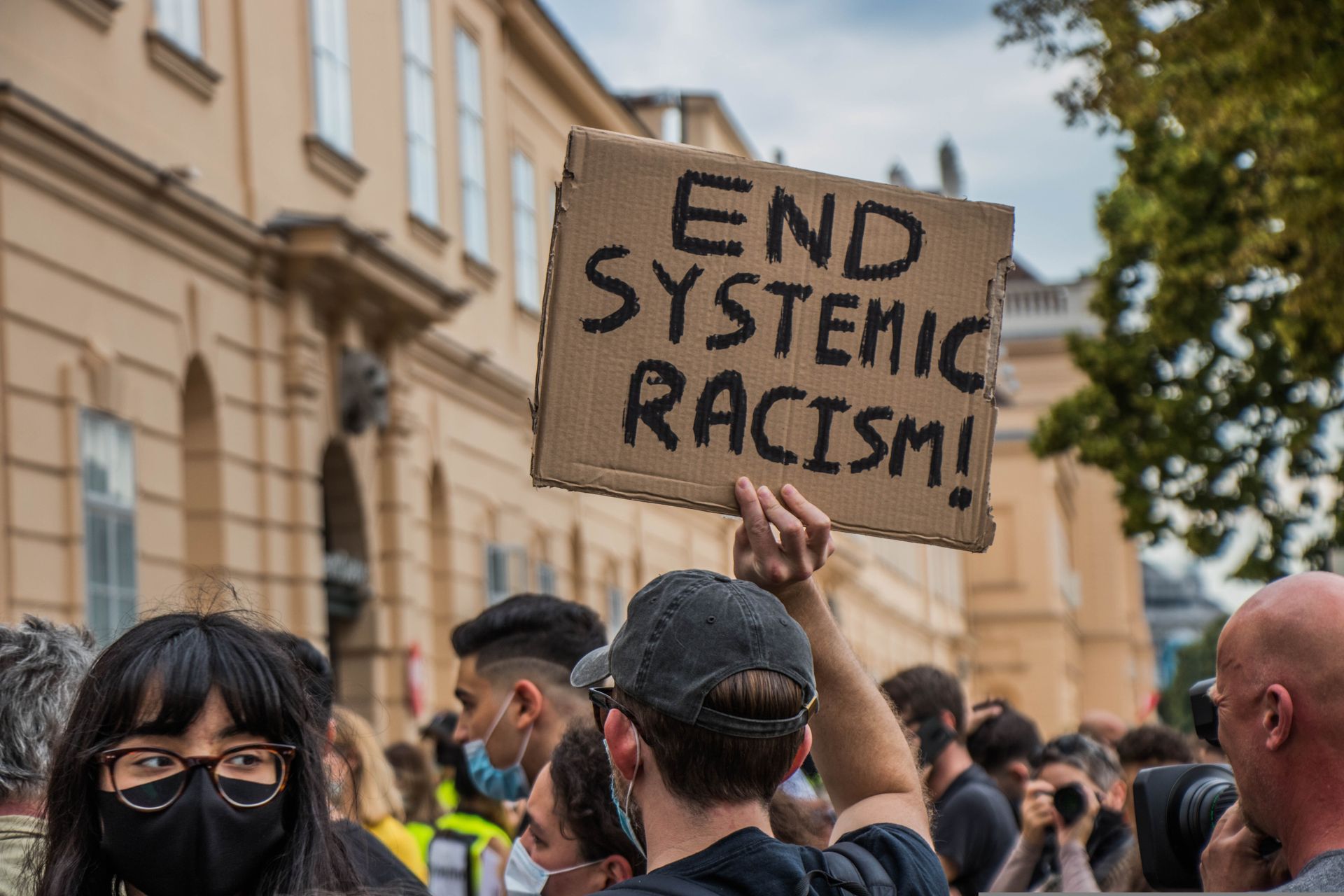 Sign held up in a crowd saying 'end systemic racism'