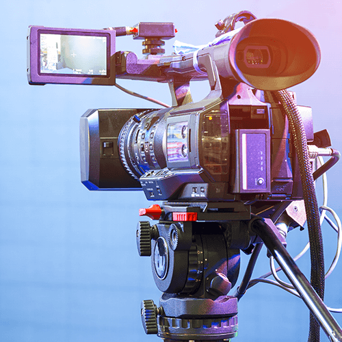 Professional video camera with flip-out screen and microphone on tripod against a blue background