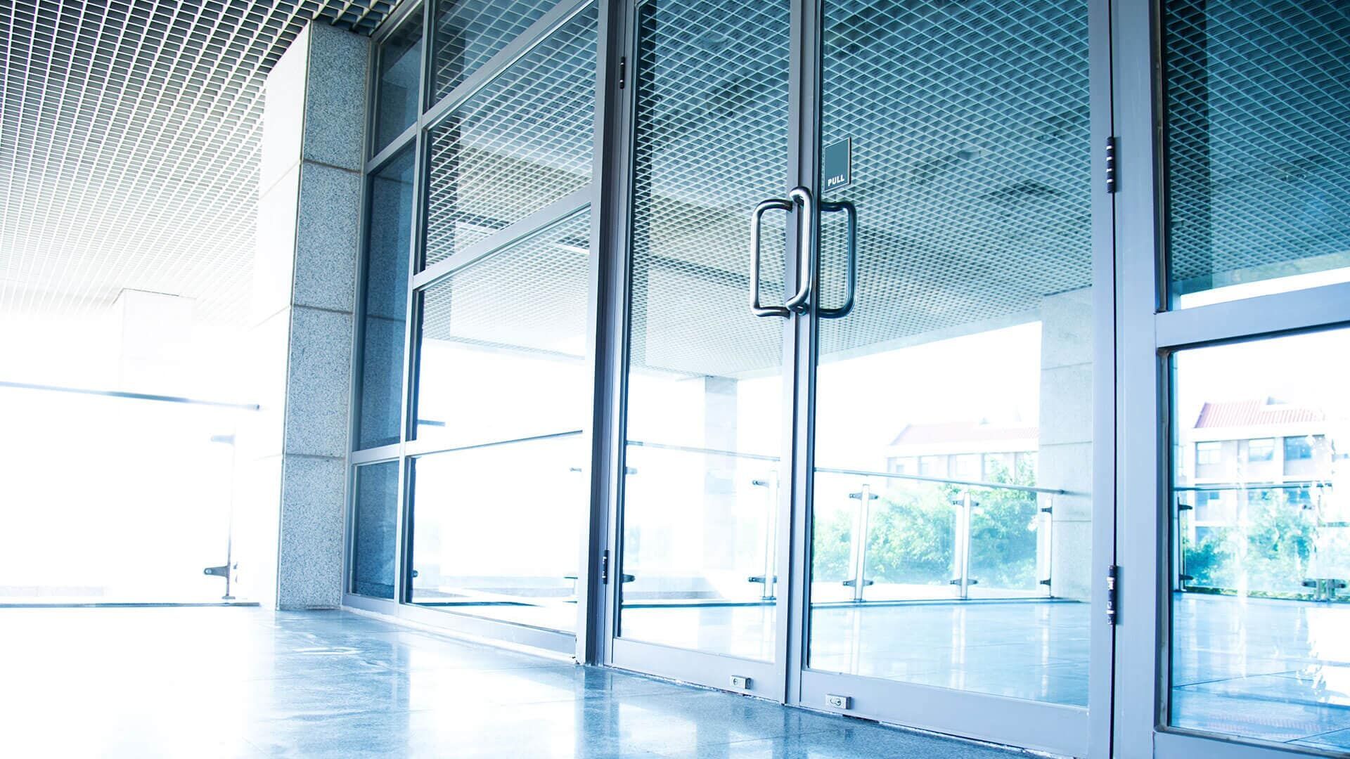 Una gran puerta de cristal en un edificio con muchas ventanas.