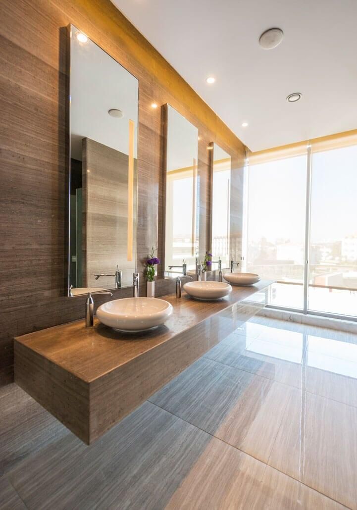 Un baño con dos lavabos y dos espejos.