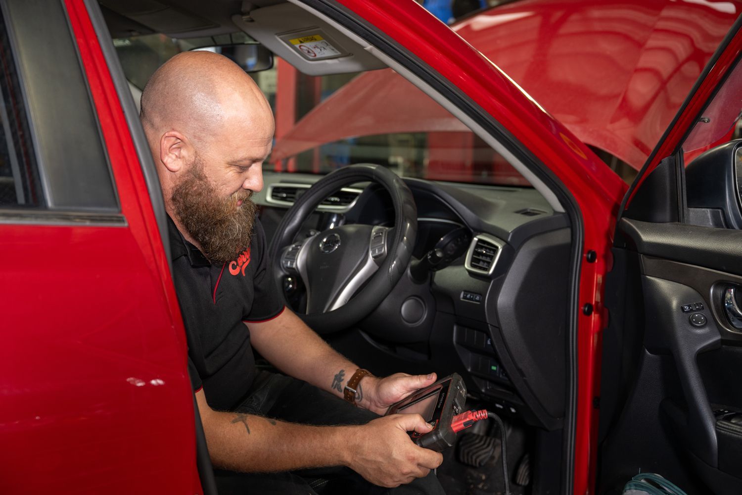A Mechanic In Maitland Servicing A Red Vehicle