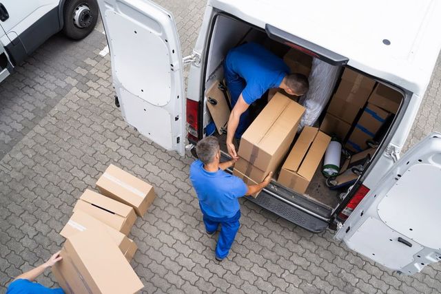 A Couple Of Men Are Loading Boxes Into A Van — CC Couriers FNQ in Portsmith, QLD