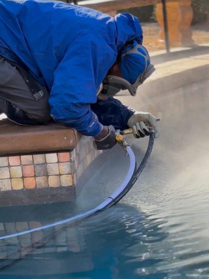 Close up of a glass bead blast nozzle cleaning pool waterline tile