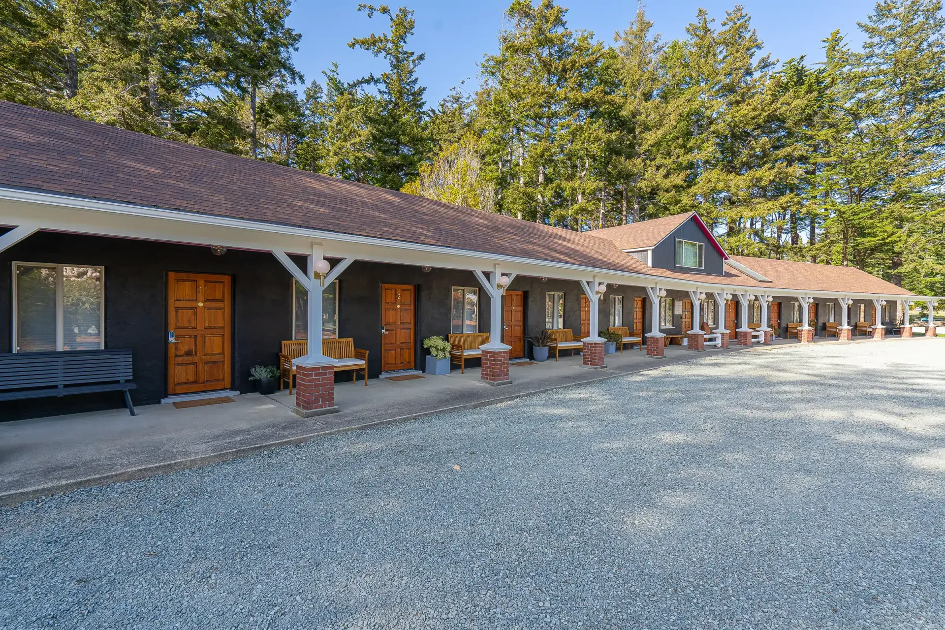A large house with a lot of windows and doors is surrounded by trees.