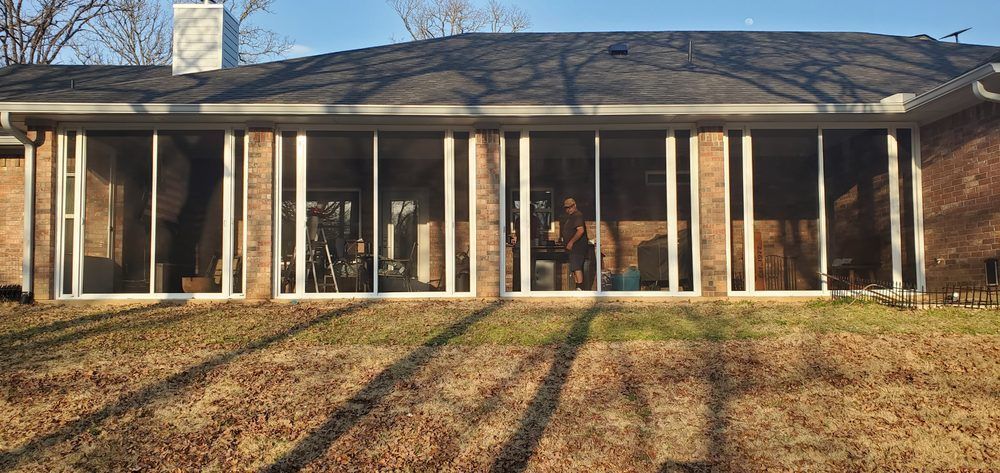 Damaged gray shingle roof with a large hole exposing underlayment and wood