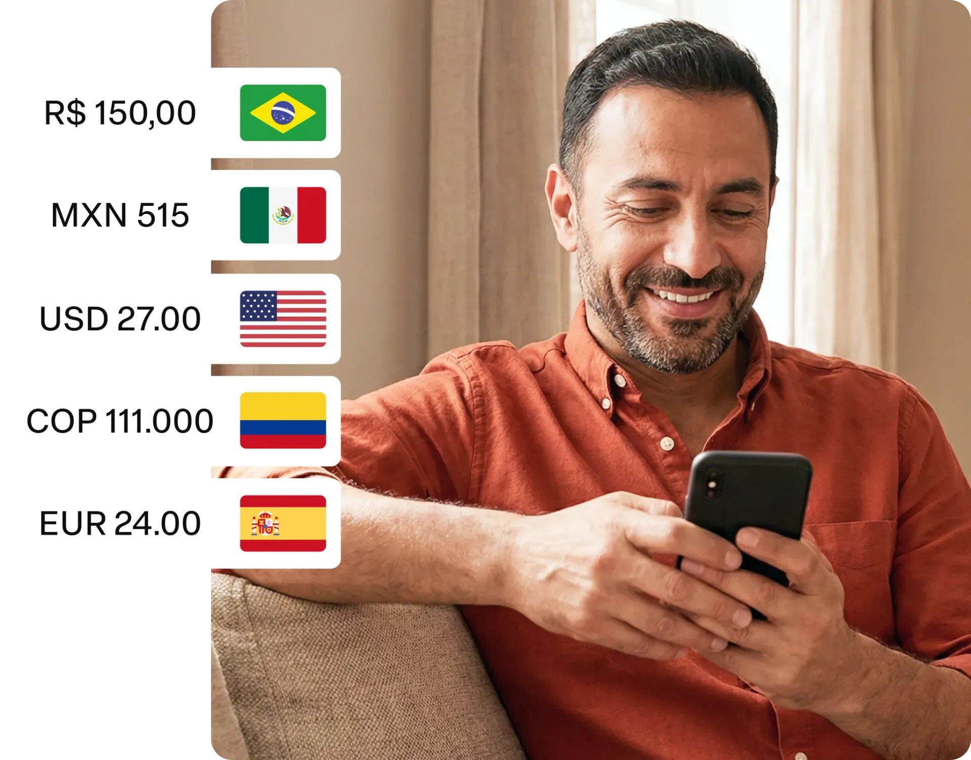 Homem sorrindo sentado em um sofá enquanto usa um telefone, com uma lista de moedas e bandeiras ao lado dele.