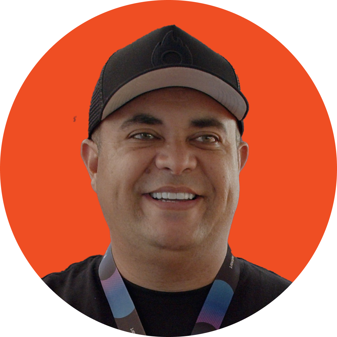Pessoa sorridente com boné preto contra um fundo circular laranja.
