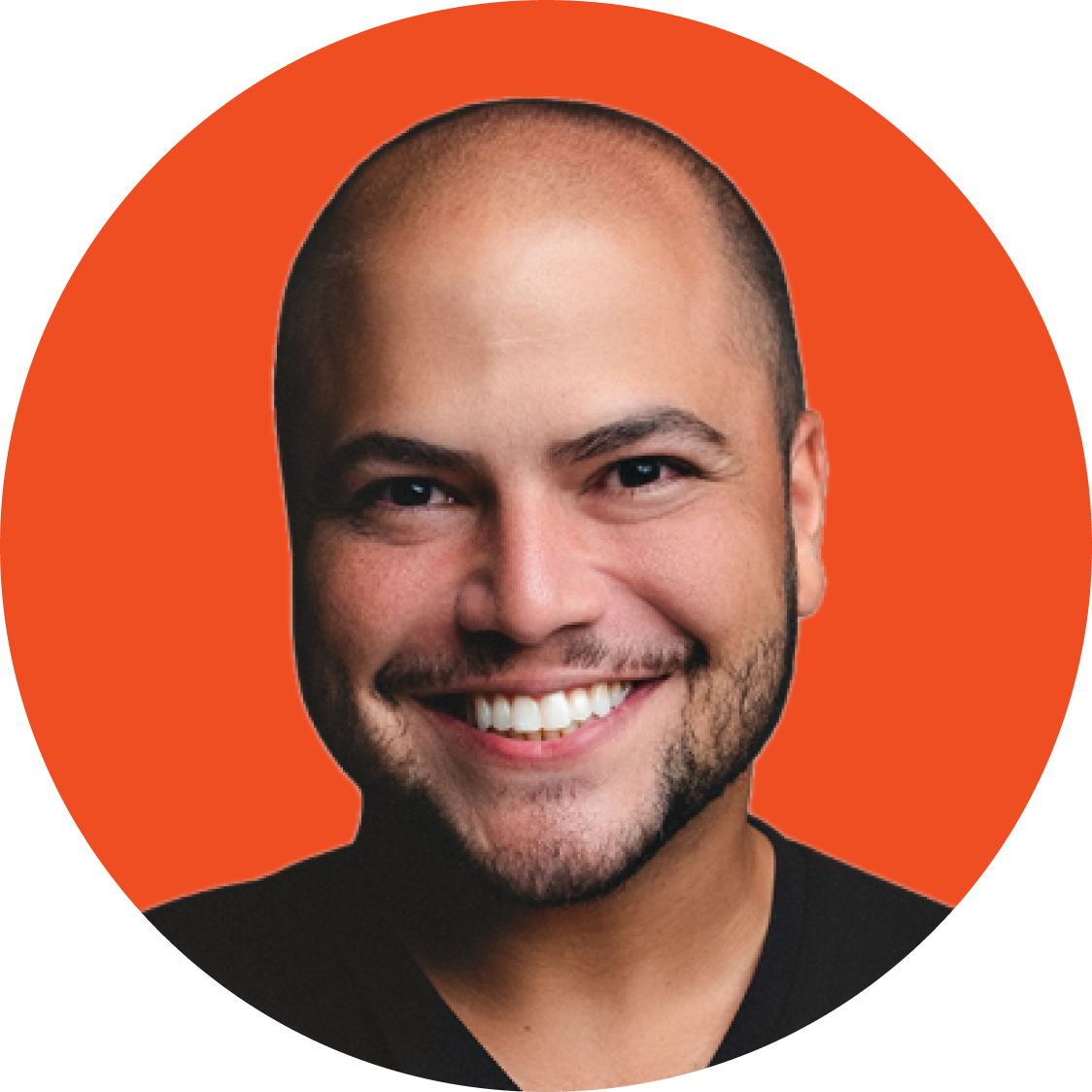 Homem careca sorridente com barba em um fundo circular laranja.