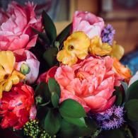 Colorful bouquet of pink, yellow, red, and purple flowers with green leaves