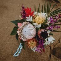 Colorful floral bouquet with white, red, pink, and purple flowers on a brown surface