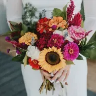 Colorful mixed flower bouquet with sunflower in a white vase