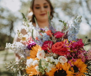 Woman holding a colorful bouquet of roses and wildflowers outdoors