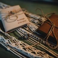 Stacked woven fabric items with tan string and a small white tag on a dark surface