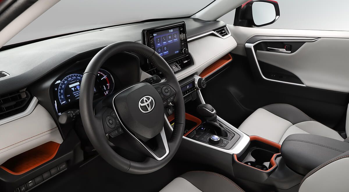 El interior de un toyota rav4 con volante y tablero.
