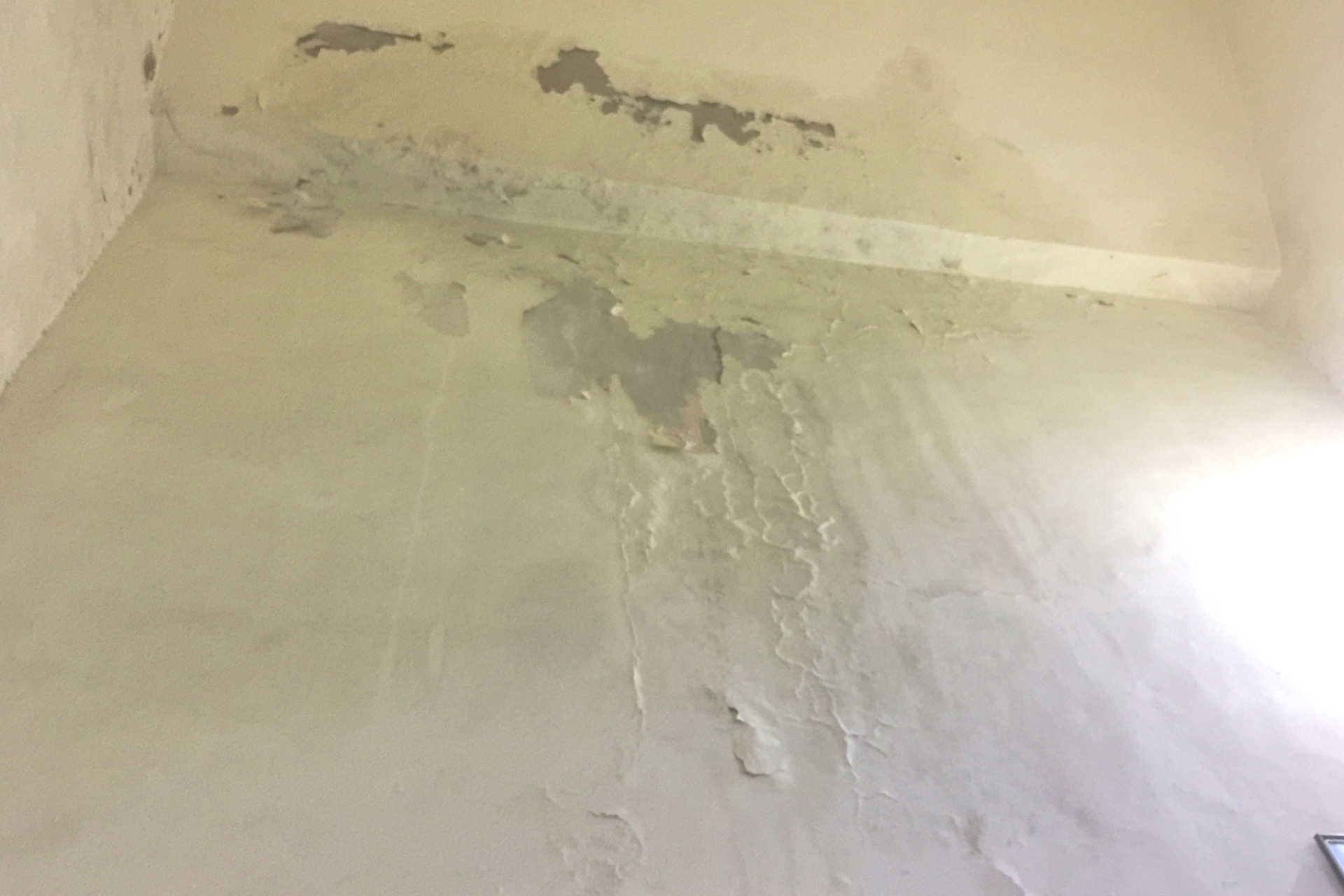 Wall with peeling paint and signs of water damage.