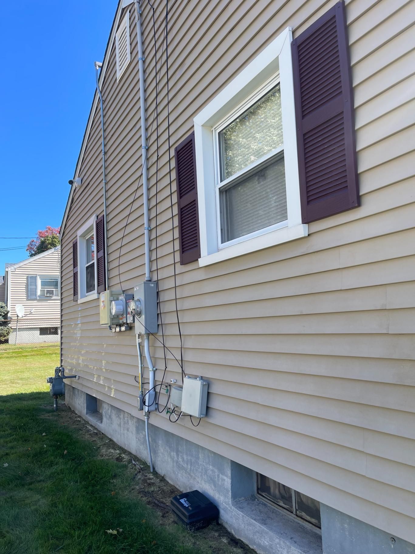 The side of a house with a lot of windows and shutters.