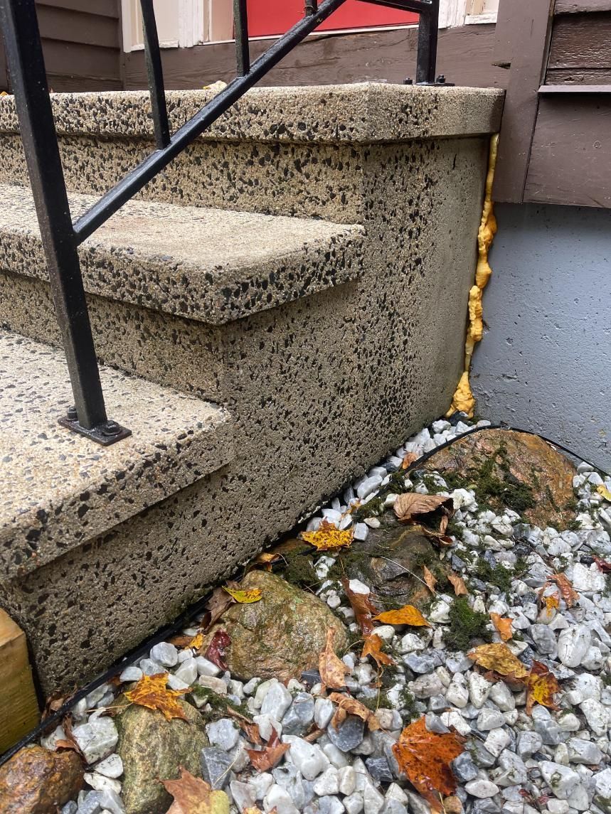 A close up of a set of stairs with leaves on the ground.