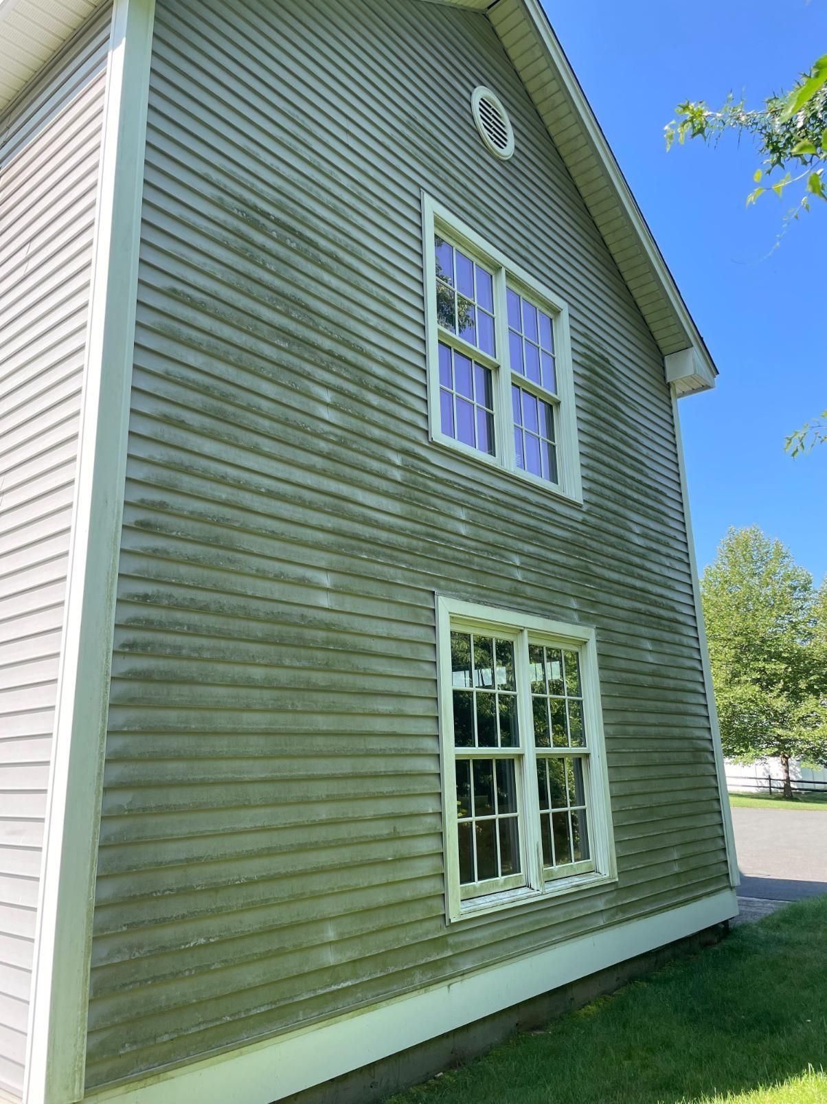 The side of a house with a lot of windows and a blue sky in the background.