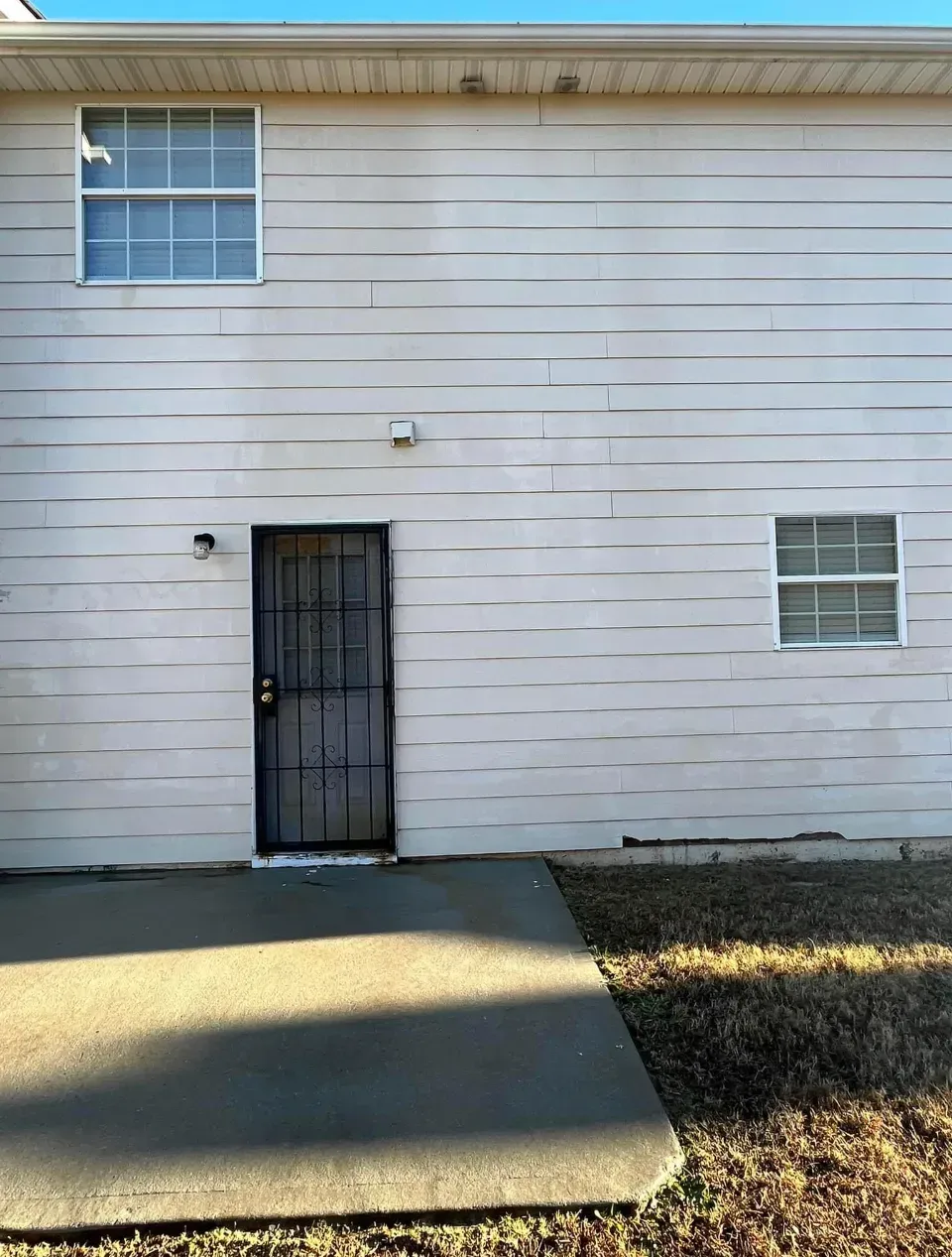 A white house with a black door and two windows.